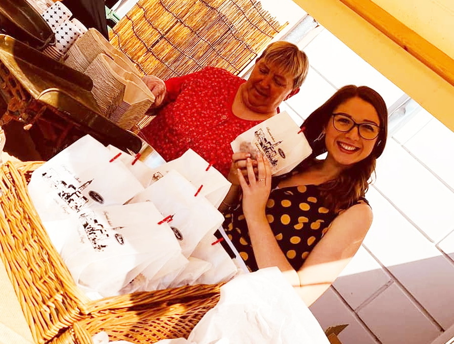 Laura Petohlep na štandu Delicie na ovogodišnjoj Subotini; u vrećici su chocoboom keksi koje su djelatnice pekle na licu mjesta. U pozadini je Adrijana Blažević, voditeljica pakiranja (foto: Facebook Delicia)